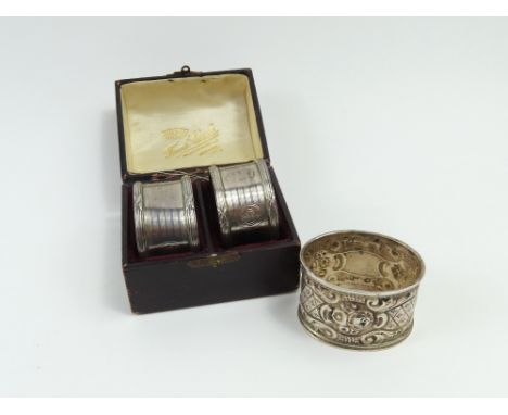 A pair of silver napkin rings, in fitted presentation case, and a single embossed napkin ring, 2.6 Troy oz