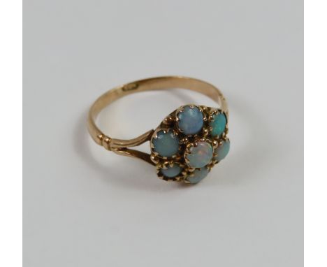 A seven stone opal cluster ring, finger size M 1/2, tests as approximately 9ct gold,1.8g gross
