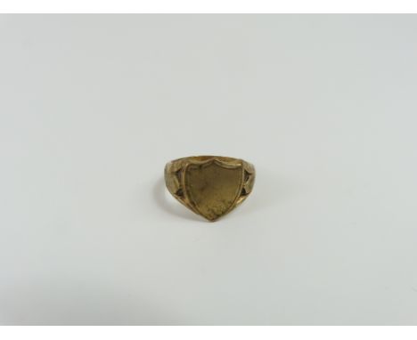 A 9ct gold signet ring, with a shield shaped head, with decorative shoulders, finger size P 1/2, 6.62g gross