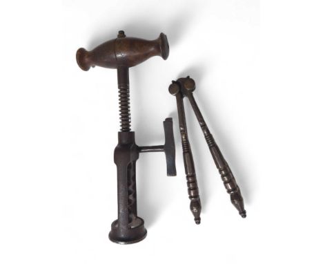 A 19th century corkscrew with shaped wood handle side mounted metal handle and open barrel together with a pair of metal nutc