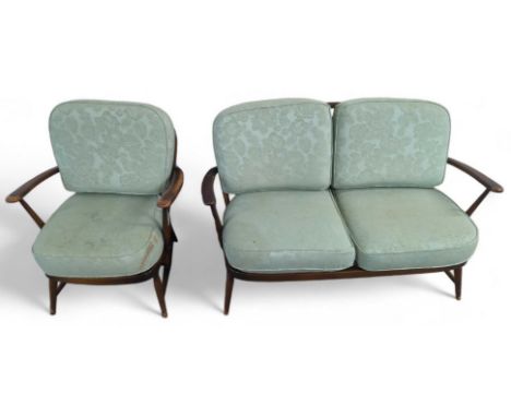 A dark Ercol two seat sofa with pale green cushions along with an arm chair of the same style