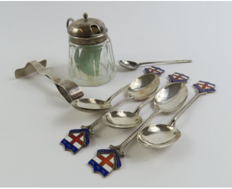 A collection of silverware comprising six spoons, an infant’s food pusher and a glass sugar pot with silver and handled lid. 