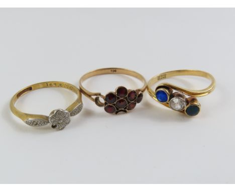 An early 20th century three stone twist ring, marked '18ct', finger size M; a diamond set flat cluster ring, marked 'plat 18c