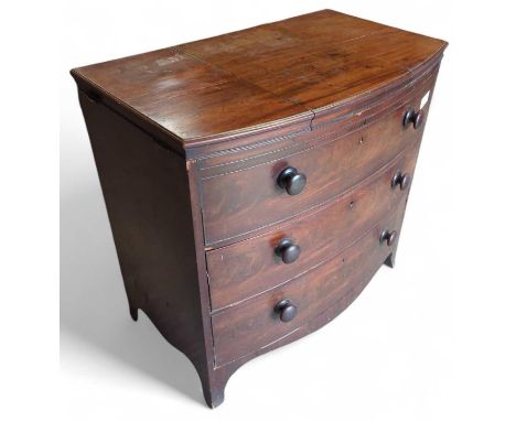 A 19th century mahogany bow fronted gentleman's dressing chest of three long drawers, the top drawer being a dummy, with roun