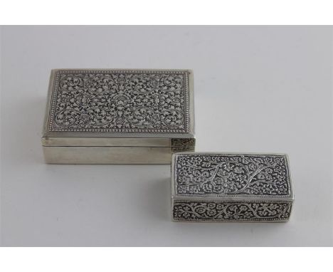 A continental silver cigarette box, of diminutive size, having intricately embossed lid and a wood lined interior, stamped .9