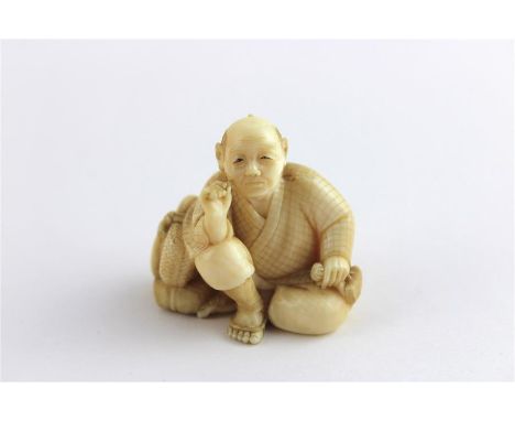 A Japanese Meiji period Ivory netsuke of a seated man smoking pipe, late 19th century, having inset engraved gold and red pla