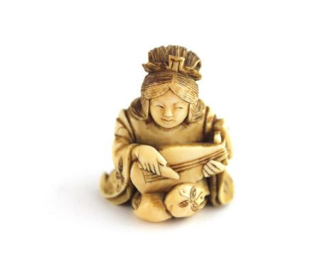 A Japanese Meiji period Ivory netsuke of a kneeling musician, late 19th century. Height 4 cm.