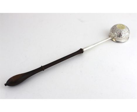 A silver toddy ladle, having repousse embossed circular bowl with Queen Anne 1711 shilling to base, tapering silver stem term