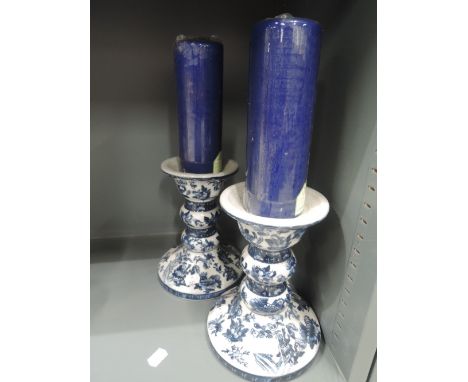 A pair of large standing ceramic candle sticks with transfer style print