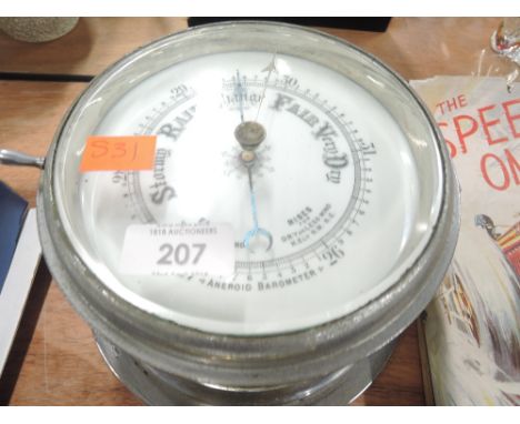 A vintage port hole style aneroid barometer with enamel face 