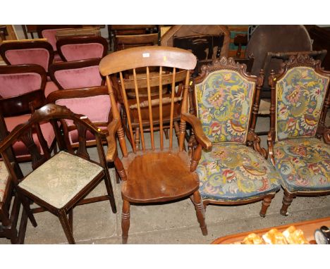A Victorian elm seated stick back kitchen elbow chair 