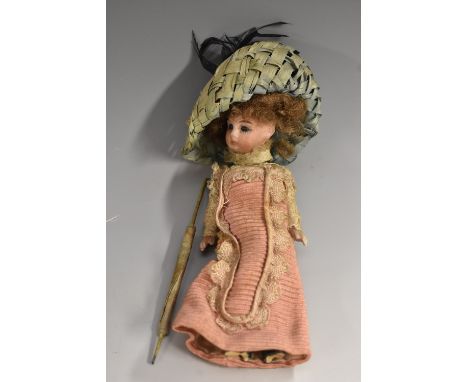 An early 20th century miniature bisque head doll, fixed blue eyes, closed mouth, painted details, curly brown hair, ceramic b