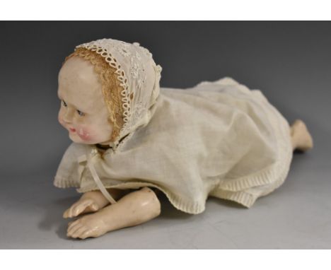 An early 20th century clockwork automation Creeping Baby Doll toy, hollow cast moulded head, painted blue eyes, rosy cheeks, 