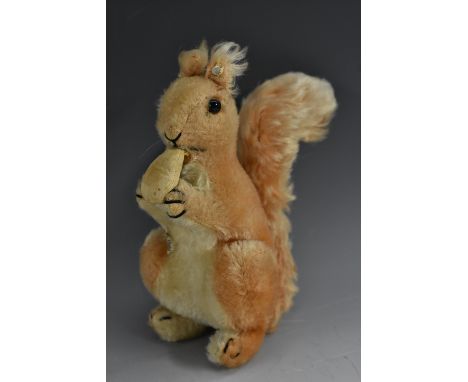 Steiff Toys - a mid 20th century stuffed toy, Squirrel Eating a Nut, button to ear, 21cm high, c.1955