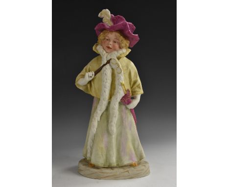 A Gebruder Heubach bisque figure, of  a  young girl, she stands, dressed as an elderly lady, wearing a feathered bonnet and f