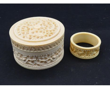 An antique Chinese carved and pierced screw lidded ivory box with dragons along with a carved ivory napkin ring with roses. H