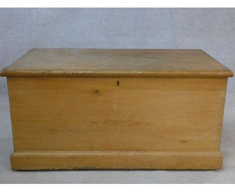 A 19th century pine hinged lidded travelling trunk with twin iron carrying handles. H.50 L.101 W.54cm 