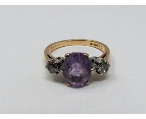 A 9ct yellow gold and white metal three stone ring, set with purple and white paste stones. Shank marked 9ct, 375, G8TI. With