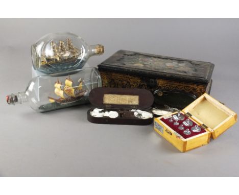 A group of works of art including a papier mache writing box, three apothecary scales, boxed weights, two ships in bottles an