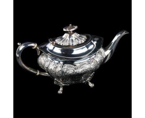 A late Victorian silver teapot, shaped oval form with relief embossed foliate decoration and ivory insulators, by George Edwa