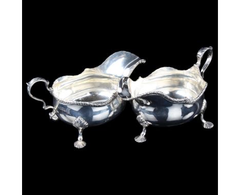 A large pair of Edwardian silver sauce boats, bulbous form with gadrooned rim, shell feet and acanthus leaf handle, by Thomas