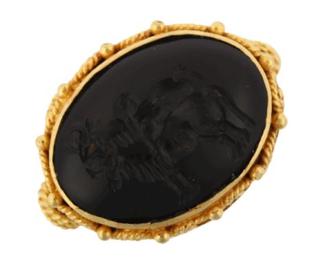 A Victorian style seal ring, unmarked yellow metal settings with wirework surround and intaglio carved stone depicting 2 bull