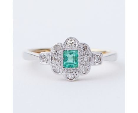 An 18ct yellow gold &amp; platinum Art Deco ring set with a central step cut emerald, approx. 0.27 carats, surrounded by smal