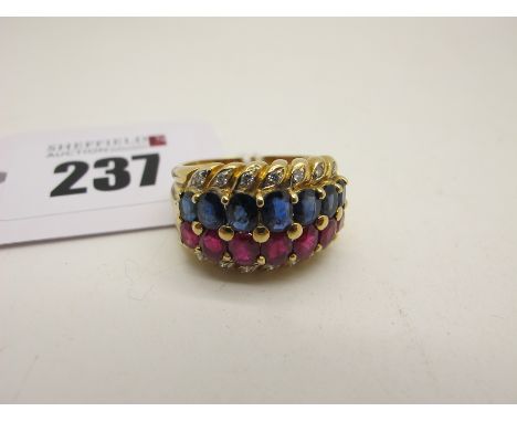 A Modern 18ct Gold Ruby and Sapphire Set Dress Ring, of two row design, claw set, with diamond set highlights (finger size P)