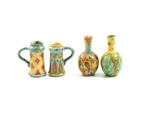 Four Della Robbia Pottery vessels, including two small ewers, one with initial F to base, the other with the initial C, both 