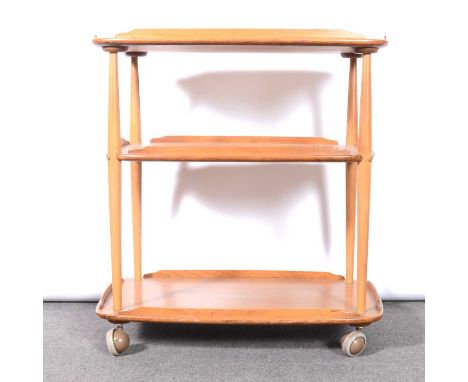 Ercol, a three-tier tea trolley, beech and elm, each tier with raised gallery outline, raised on casters, applied label, widt