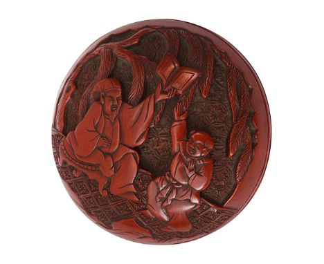 A Japanese Edo period Tsuishu red lacquer two part manju netsukecarved with Chinese sages and attendants in a landscape with 