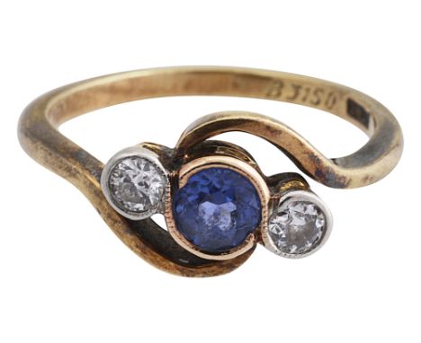 A sapphire and diamond three stone cross-over ring the central bezel set round brilliant cut sapphire, between two round bril