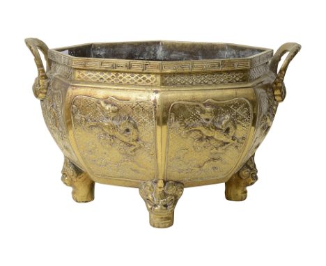 A large late 19th century Chinese polished bronze octagonal jardinierewith twin phoenix handles, the sides cast in relief wit