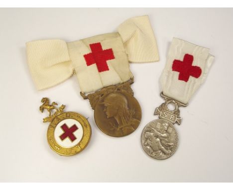 NURSING MEDALS. Two WWI French Red Cross nursing medals with ribbons & a brass & enamel V.A.D. nurses badge.