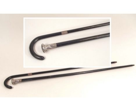 WALKING STICKS.A silver mounted walking cane, stamped Kendal & an ebonised walking stick with silver collar.