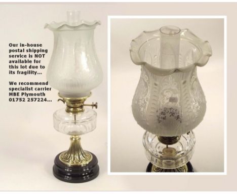 OIL LAMP. A 19th century oil lamp with clear glass fount & cherub decorated shade. Height 55cm.