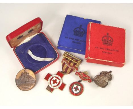 RED CROSS MEDALS ETC.Two British Red Cross Society medals, one silver gilt, both named (enamel damage), a silver ARP badge & 