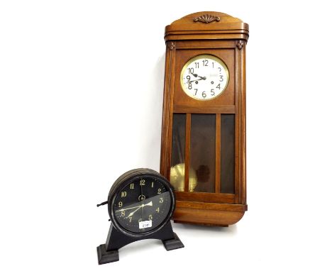 Interesting gravity shelf clock, the 7" dial behind a compound pendulum within a blackened metal surround upon an ebonised ba