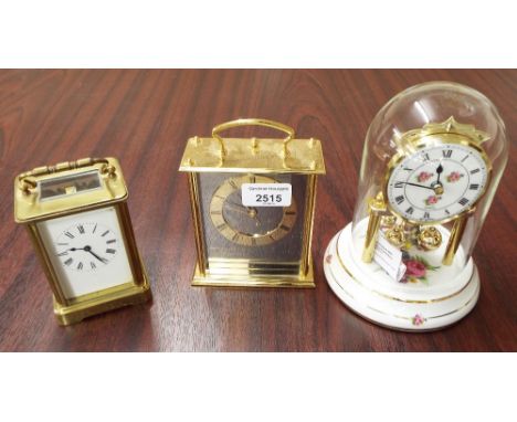French brass carriage timepiece, modern Seiko brass quartz carriage timepiece and a modern porcelain torsion clock beneath a 