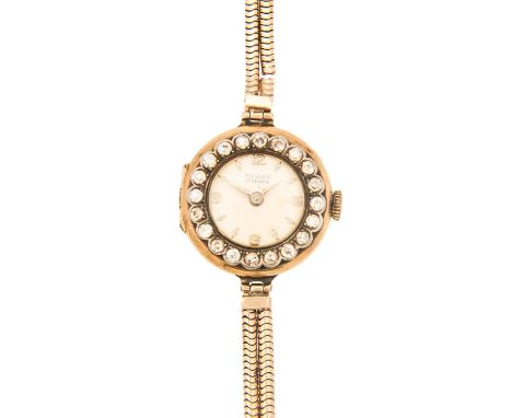 An early 20th century 18ct cased lady's gold manual wristwatch with diamond set bezel, on a 9ct bracelet. The 14mm silvered d