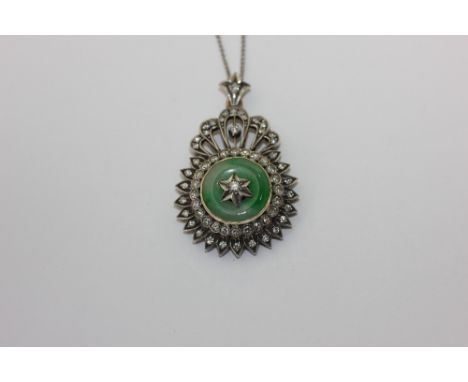 A jade and diamond pendant in white and yellow gold