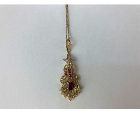 A ruby and diamond pendant set with a pear cut ruby and graduated rose cut diamonds