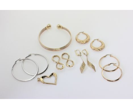 A 9ct three colour gold open end bangle, a pair of 9ct white gold hoop earrings, four pairs of 9ct gold earrings and a heart 