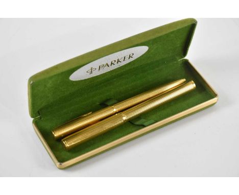 DUNHILL; a gold plated fountain pen and roller ball pen, with engine turned detailing, with ‘585’ nib, in an associated box.