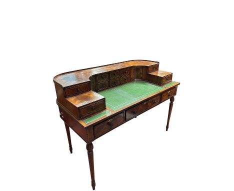 A walnut and rosewood Carlton House style desk, with an arrangement of ten drawers and two doors above three drawers, on turn