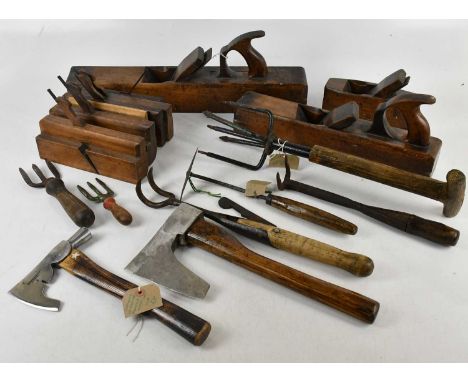 A collection of vintage farming/gardening and woodworking tools including planes, various axes including Cornelius Whitehouse