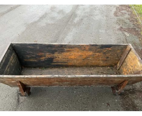 A large 19th century dough trough on associated frame and wheels, length 235cm.