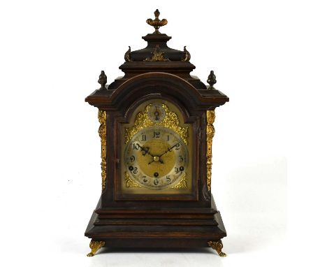 A late 19th century German mantel clock with urn finial, the face set with Arabic numerals and chime/silent dial, height 50cm
