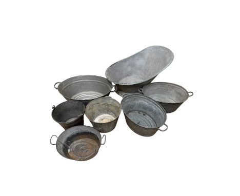 A collection of vintage galvenised items including twin handled bowls, a milking bucket and a large washing bowl, length 90cm