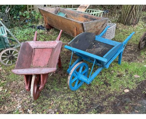 A vintage wooden blue painted wheel barrow with cast iron and wooden wheel, length 167cm, and a similar red painted smaller e